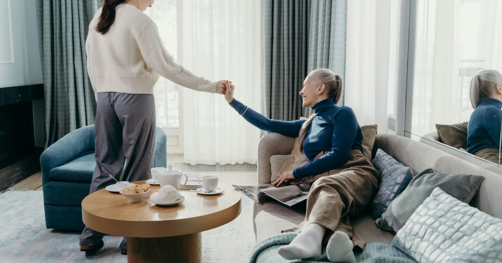 A senior woman and her adult daughter sharing a relaxed, affectionate moment together at home.